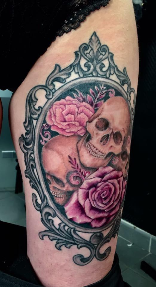 Tatouage de tète de morts avec des rose sur un miroir sur une jambe